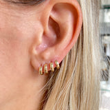 Four 14k gold tiniest biggie hoops. Our classic Huggie made for stacking or worn alone.