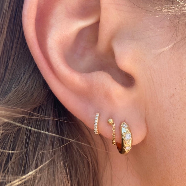 Our sun & stars huggie hoops are paired with the chained together studs and the tiniest diamond huggies to complete this ear stack