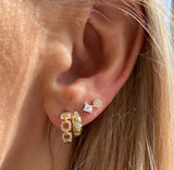 Our sun & stars huggie hoops are paired with our diamond chain link huggies, our very special princess cut diamond studs, and our tiniest diamond disc studs.