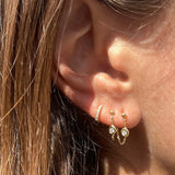 The bezel diamond chain earrings are paired with our best selling tiniest diamond huggie hoops